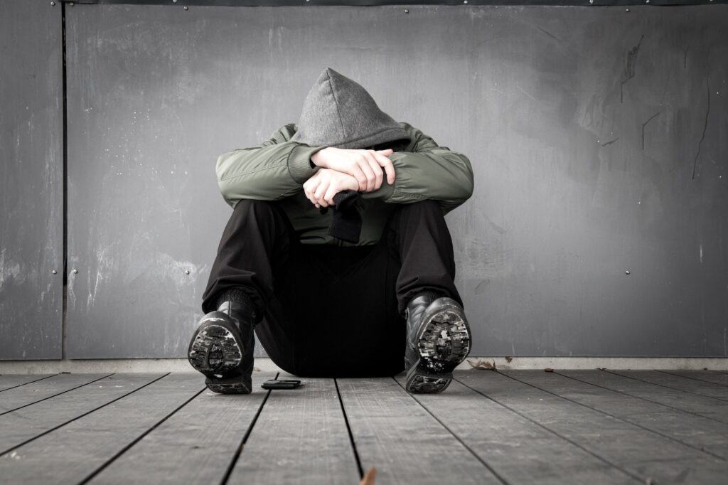 Lonely and sad man sitting on the ground